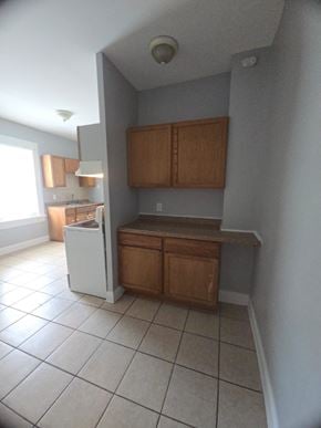 Cincinnati house for rent - A kitchen with white appliances and wooden cabinets.