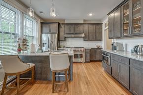 Richmond apartment for rent - A kitchen with wooden floors and a large island with two chairs.