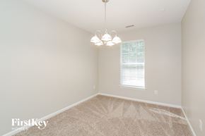 Charlotte house for rent - a bedroom with carpet and a chandelier and a window