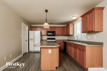 Wentzville house for rent - A kitchen with wooden cabinets and a white fridge.