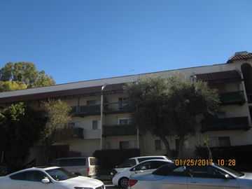 Encino apartment for rent - A white car is parked in front of a white van.