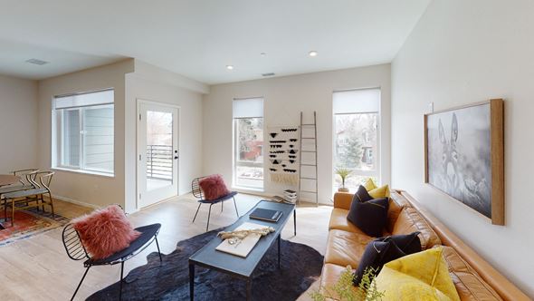 Denver apartment for rent - A living room with a brown couch, a black coffee table, and a painting on the wall.