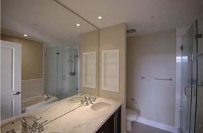 Vancouver apartment for rent - A bathroom with a large mirror, a sink, and a walk-in shower.