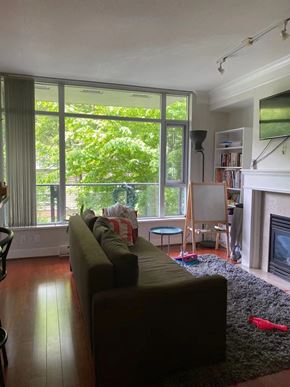 Vancouver apartment for rent - A living room with a couch, a chair, a fireplace, and a bookshelf.