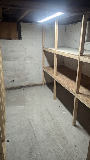 Woonsocket apartment for rent - A room with a concrete floor and a concrete wall with a light on.