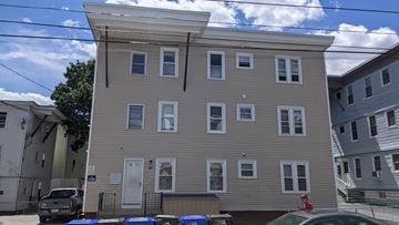 Central Falls apartment for rent - A two-story building with a grey facade and white trim.