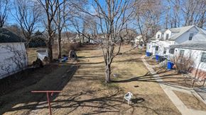 West Warwick apartment for rent - a dog is standing in a yard in front of some houses