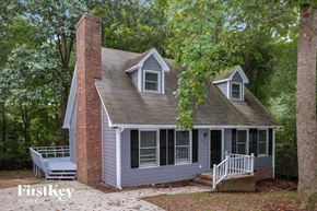 Trinity house for rent - A house with a brick chimney and a porch.