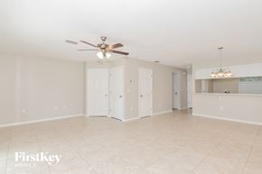 Sarasota house for rent - A spacious room with a ceiling fan and a chandelier.