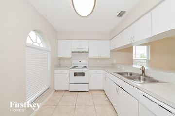 Sarasota house for rent - A kitchen with white cabinets and appliances.