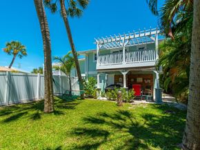 Holmes Beach house for rent - the front of the house with palm trees
