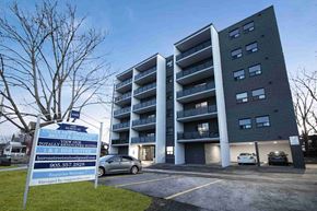Niagara Falls apartment for rent - an apartment building with a parking lot and a sign in front of it