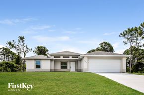 Lehigh Acres house for rent - a white house with a lawn in front of it