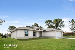 Lehigh Acres house for rent - a white house with a yard and a blue sky