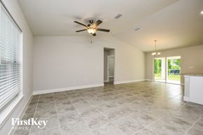Lehigh Acres house for rent - the spacious living room with tile flooring and a ceiling fan