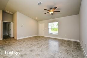 Lehigh Acres house for rent - the spacious living room with tile flooring and a ceiling fan