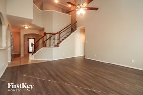 Humble house for rent - a living room with a staircase and a ceiling fan