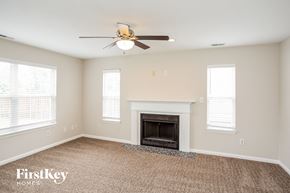 Westfield house for rent - A spacious room with a fireplace and a ceiling fan.