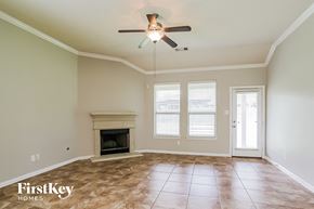 Porter house for rent - A room with a fireplace and a ceiling fan.