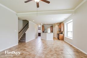 Porter house for rent - A spacious living room with a staircase and a ceiling fan.