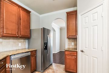 Porter house for rent - A kitchen with wooden cabinets and a stainless steel refrigerator.