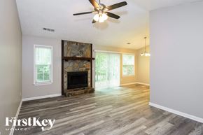 Kennesaw house for rent - A room with a fireplace and a ceiling fan.