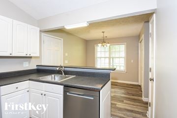 Kennesaw house for rent - A kitchen with white cabinets and a black countertop.