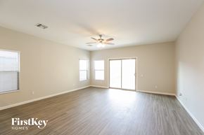 Laveen house for rent - an empty living room with wood floors and a ceiling fan