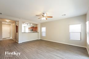 Laveen house for rent - an empty living room with a ceiling fan and a kitchen