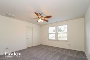 Winston Salem house for rent - A room with a ceiling fan and a window with a view of trees.