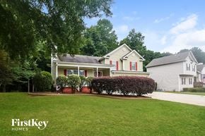 Acworth house for rent - A house with a lawn and trees in front of it.