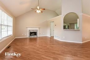 Acworth house for rent - A spacious living room with wood flooring and a fireplace.
