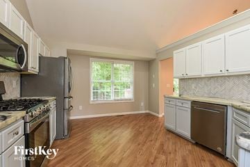 Acworth house for rent - A kitchen with wooden floors and a stove top oven.