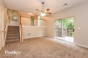 Acworth house for rent - A spacious room with a staircase and a ceiling fan.