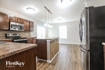 Camby house for rent - A kitchen with wooden cabinets and a granite countertop.