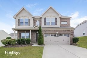 Mooresville house for rent - a house with a white garage door in front of a lawn