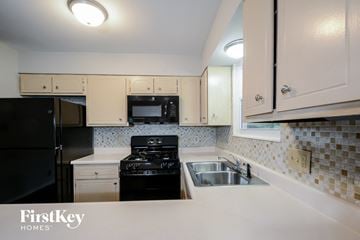 Manchester house for rent - A kitchen with a black stove top oven and a black refrigerator.