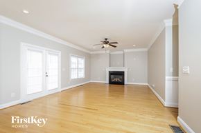 Clemmons house for rent - A spacious living room with a fireplace and a ceiling fan.