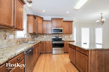 Clemmons house for rent - A kitchen with wooden cabinets and a granite countertop.