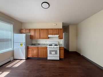 New Haven apartment for rent - A kitchen with wooden cabinets and a white fridge.