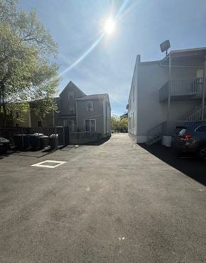 New Haven apartment for rent - A sunny day in a parking lot with a car parked on the right side.
