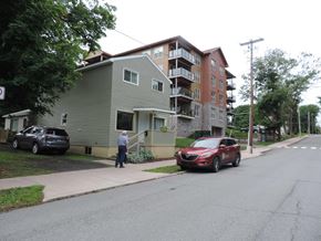 New Glasgow apartment for rent - a man walking down a sidewalk in front of an apartment building