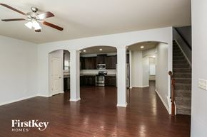 Woodstock house for rent - A spacious living room with a wood floor and a ceiling fan.