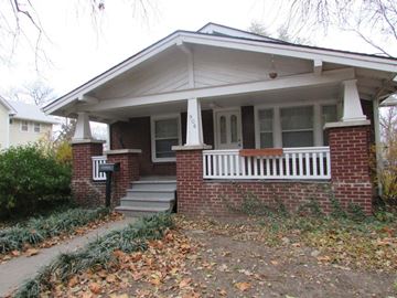Lawrence apartment for rent - A house with a white porch and a brick base.