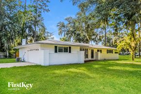 Orange Park house for rent - A white house with a porch and a tree in front.