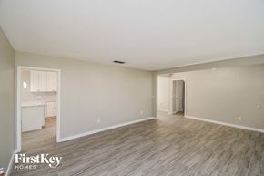 Orange Park house for rent - A spacious room with wooden flooring and a doorway leading to another room.