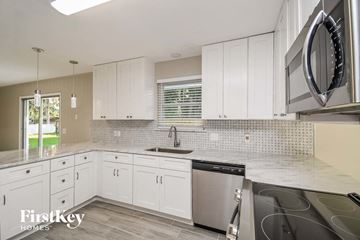 Orange Park house for rent - A kitchen with white cabinets and a stainless steel dishwasher.