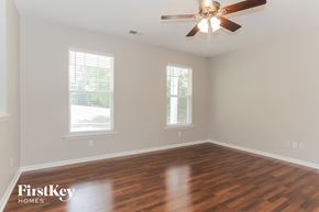 Charlotte house for rent - a living room with wood floors and a ceiling fan