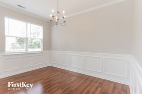 Charlotte house for rent - the dining room of a home with wood floors and a chandelier