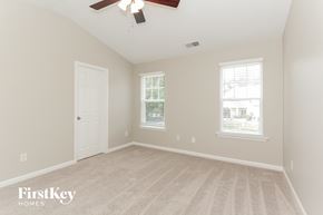 Charlotte house for rent - a bedroom with a ceiling fan and a white door